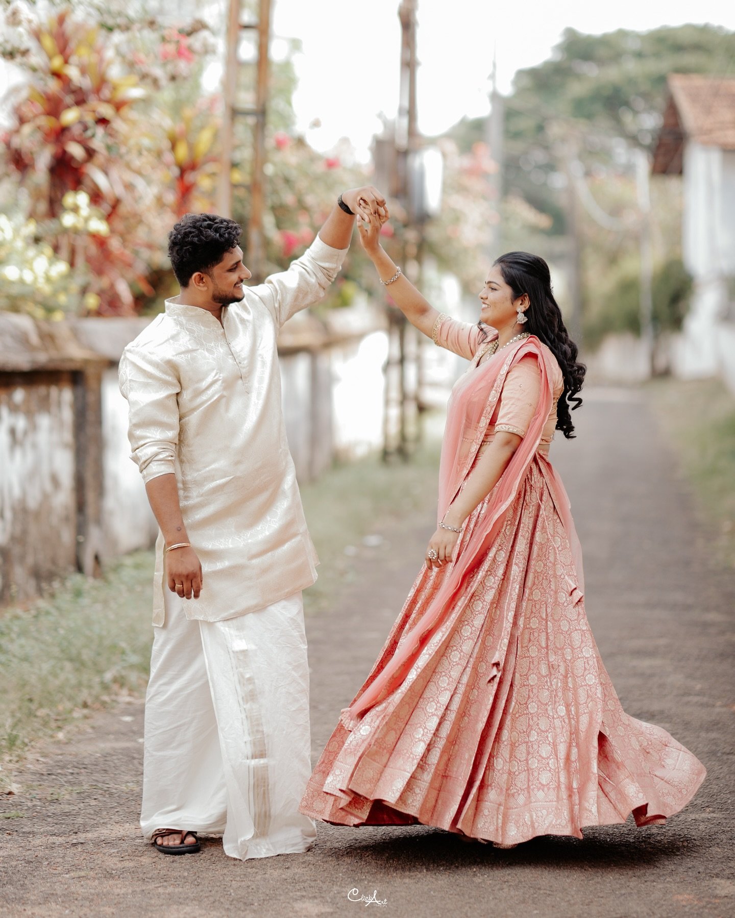 A couple dancing together in traditional celebration attire